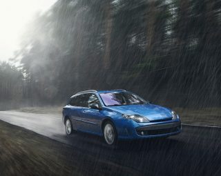 Blue car fast drive on wet road in rain at daytime