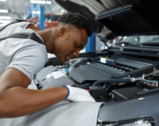 Male mechanic checks engine