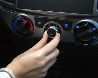 Woman turning on car air conditioning